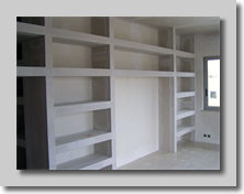 Βιβλιοθήκη με ράφια απο γυψοσανίδα και άνοιγμα για γραφείο